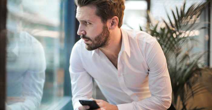 japanese man looking at phone thoughtful