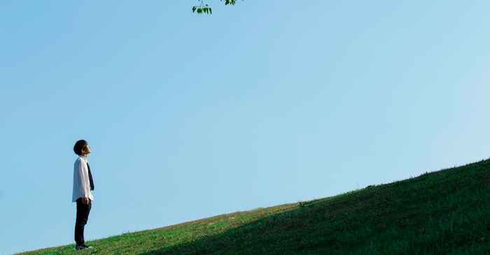 young japanese man smiling looking hopeful future