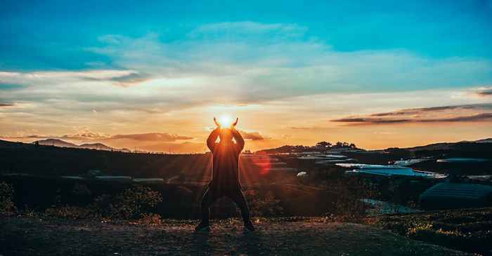 young japanese man looking horizon sunrise confident new beginning