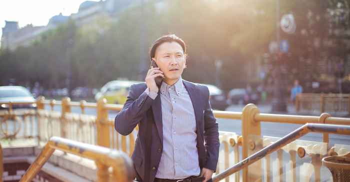 japanese man smartphone walking city confident