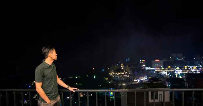 young man nervous looking at night city lights