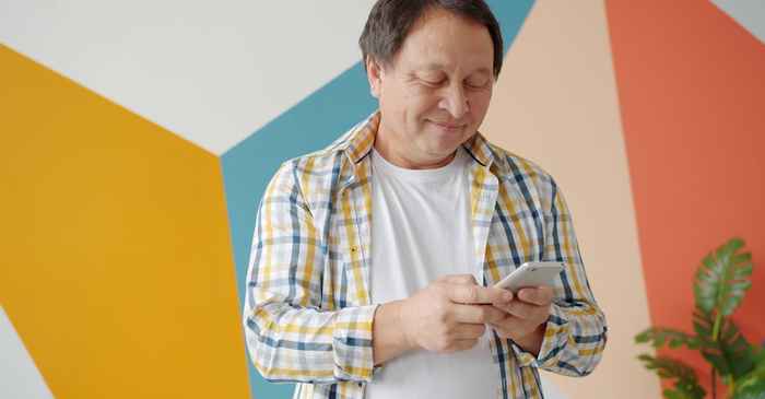 japanese man smartphone home comfortable smiling chat messaging