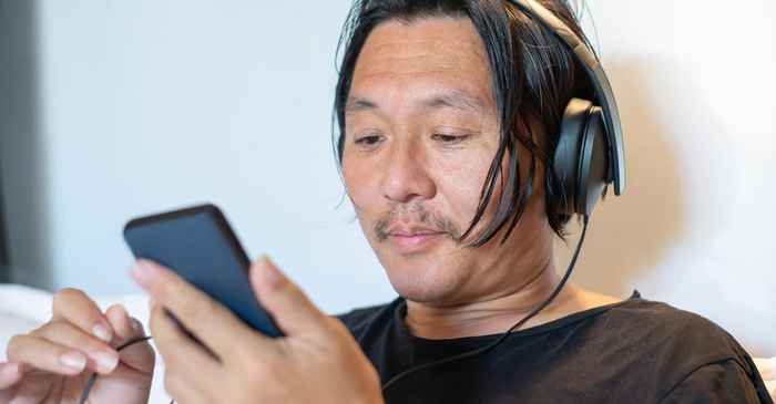 japanese man smartphone happy looking at screen satisfied