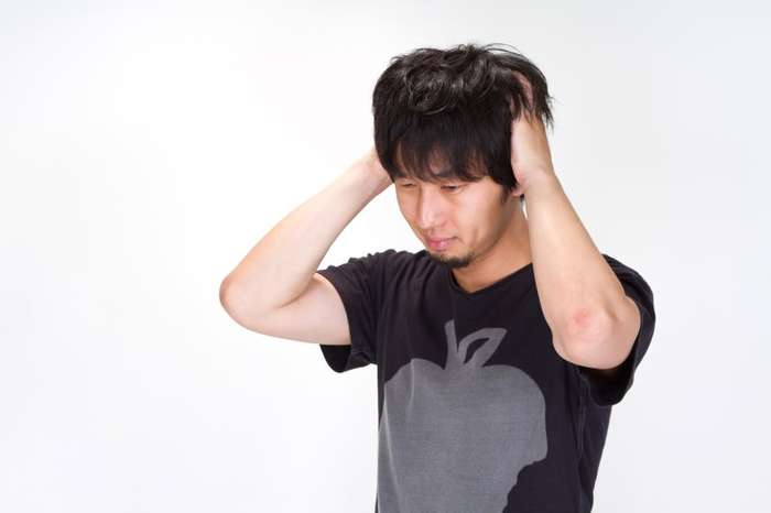 童貞卒業の方法を考えながら屋外で悩む男性
